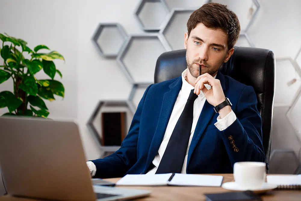 young-successful-businessman-sitting-workplace-office-background